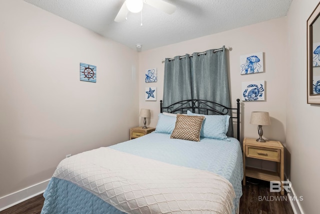 bedroom featuring dark hardwood / wood-style flooring, ceiling fan, and a textured ceiling