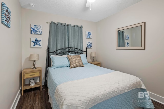 bedroom with a textured ceiling, ceiling fan, and dark wood-type flooring