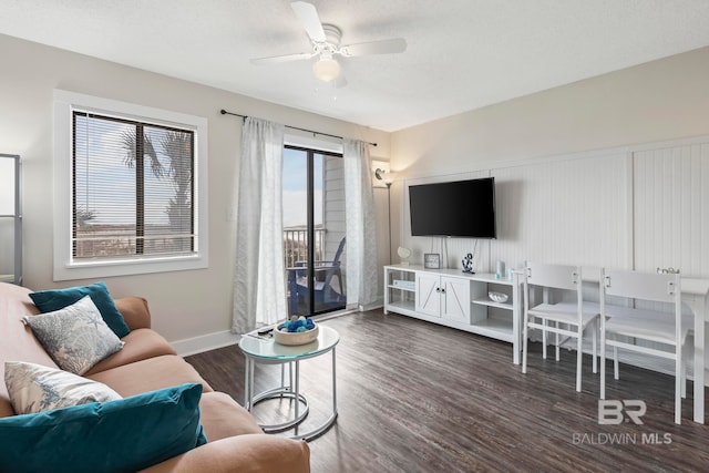 living room featuring dark hardwood / wood-style flooring, ceiling fan, and a wealth of natural light