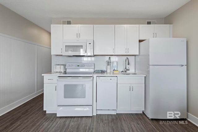 kitchen with backsplash, dark hardwood / wood-style floors, white appliances, sink, and white cabinets