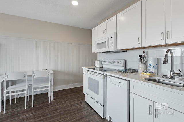 kitchen with white appliances, white cabinets, backsplash, and dark wood-type flooring