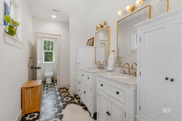 bathroom with double vanity, radiator, toilet, and tile patterned floors