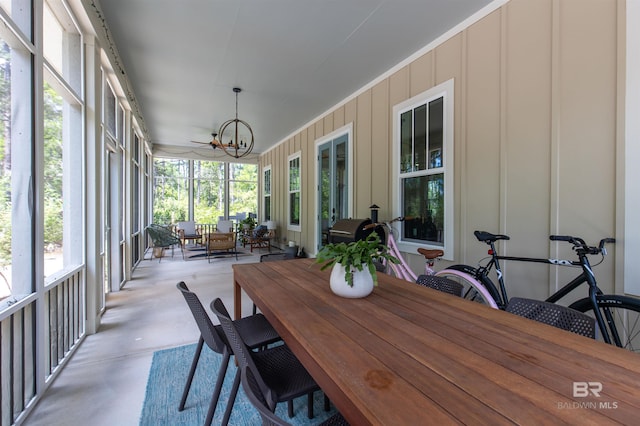 sunroom / solarium featuring an inviting chandelier