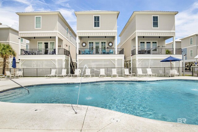 community pool with fence and a patio
