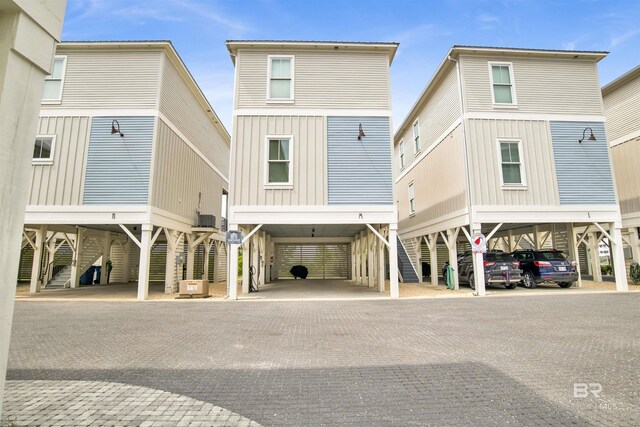 back of house featuring a carport, stairway, and driveway