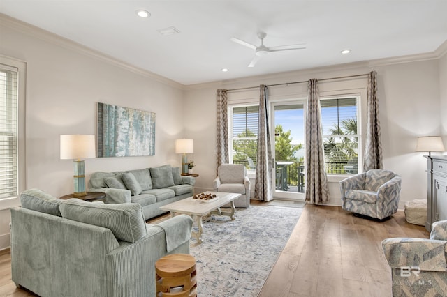 living area featuring light wood-type flooring, a ceiling fan, ornamental molding, recessed lighting, and baseboards