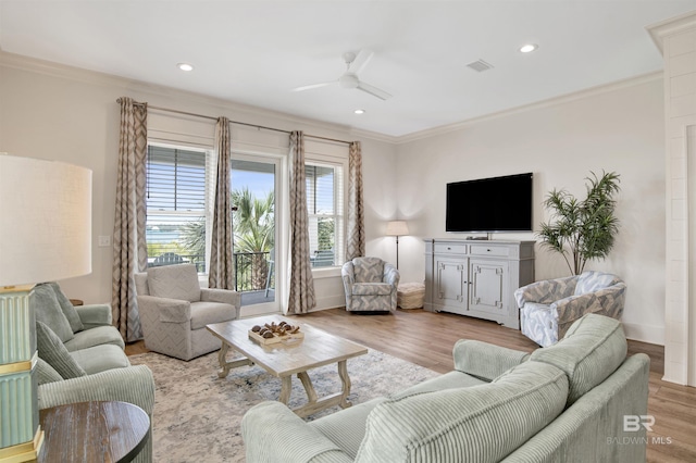 living area with ornamental molding, a ceiling fan, light wood-style floors, recessed lighting, and baseboards