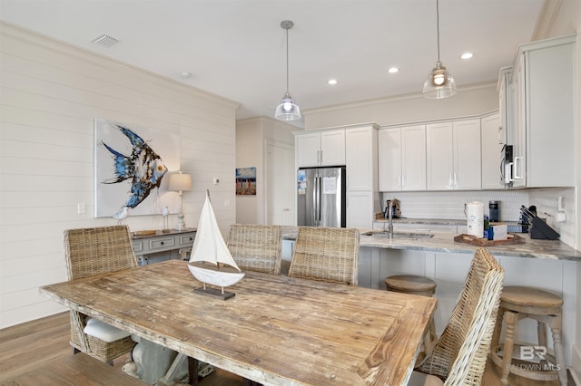 kitchen featuring stainless steel appliances, a peninsula, white cabinets, a breakfast bar area, and recessed lighting