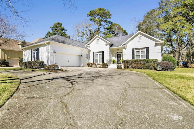 view of front of house featuring a garage, driveway, and a front lawn