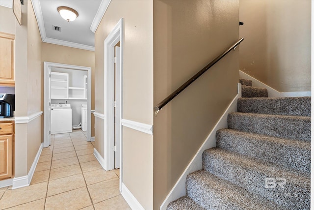 staircase featuring ornamental molding, tile patterned flooring, built in features, and washing machine and clothes dryer