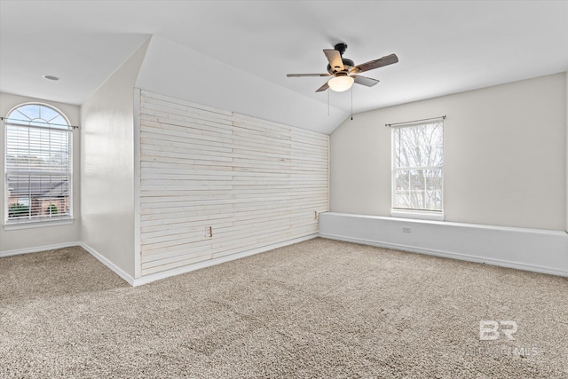 carpeted spare room featuring ceiling fan and vaulted ceiling