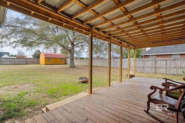 wooden terrace featuring a yard and a storage unit