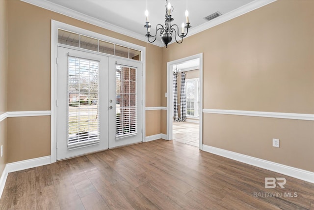 doorway to outside featuring french doors, crown molding, a chandelier, and wood-type flooring