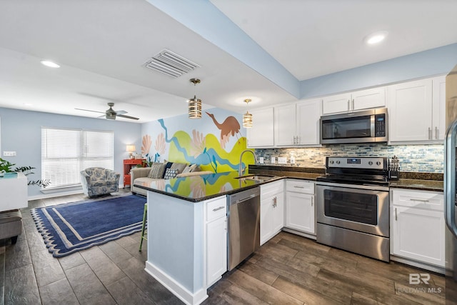 372 E Beach Blvd Unit 14, Gulf Shores, AL 36542 - kitchen featuring appliances with stainless steel finishes, a sink, a peninsula, dark countertops, and recessed lighting