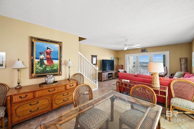 living room featuring ceiling fan and a textured ceiling