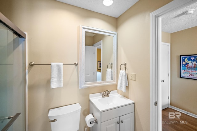 bathroom with vanity, hardwood / wood-style floors, toilet, and a textured ceiling