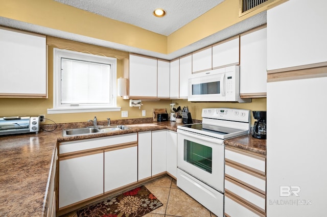 kitchen featuring white cabinetry, sink, a textured ceiling, and white appliances