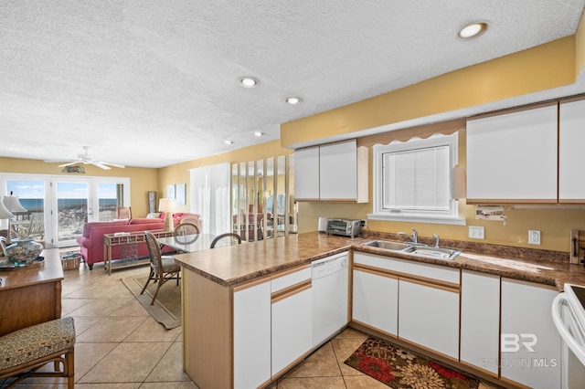 kitchen with sink, white cabinetry, kitchen peninsula, dishwasher, and stove