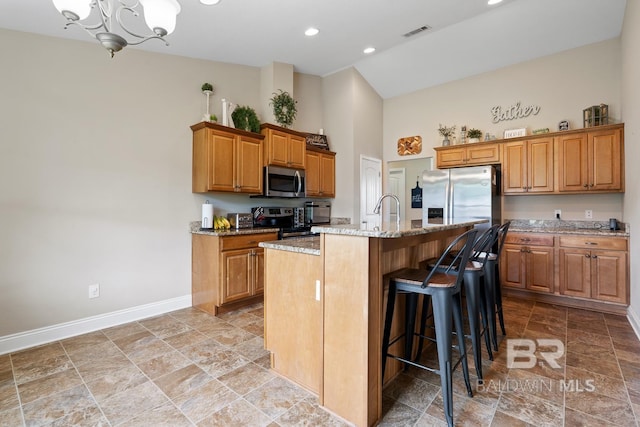 kitchen featuring stainless steel appliances, high vaulted ceiling, baseboards, light stone finish flooring, and a chandelier