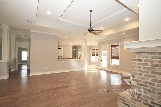 unfurnished living room with a raised ceiling, ceiling fan with notable chandelier, dark hardwood / wood-style floors, and ornamental molding