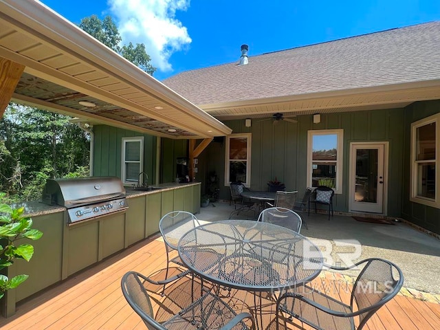 deck featuring an outdoor kitchen, area for grilling, sink, and ceiling fan