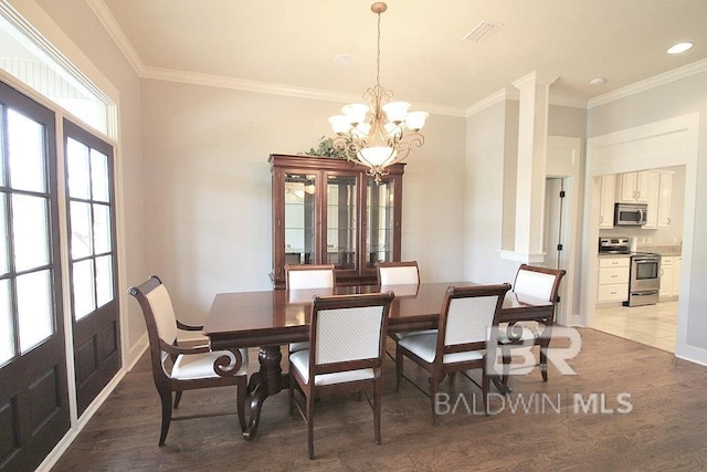 dining space featuring light hardwood / wood-style floors, crown molding, and a chandelier