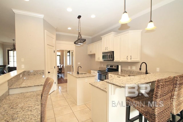 kitchen with white cabinets, light stone countertops, appliances with stainless steel finishes, kitchen peninsula, and a breakfast bar area