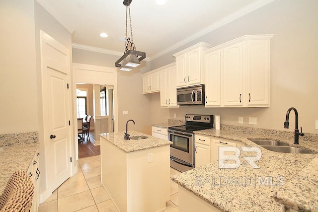 kitchen with sink, light stone countertops, stainless steel appliances, and an island with sink