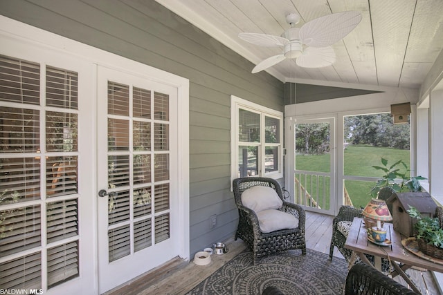 sunroom / solarium with ceiling fan, wood ceiling, and vaulted ceiling