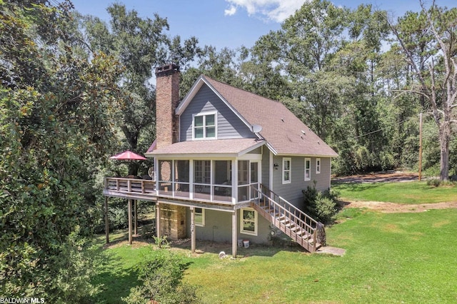 rear view of house featuring a sunroom and a yard