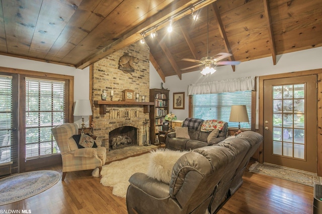 living room with lofted ceiling with beams, a brick fireplace, dark hardwood / wood-style flooring, and ceiling fan