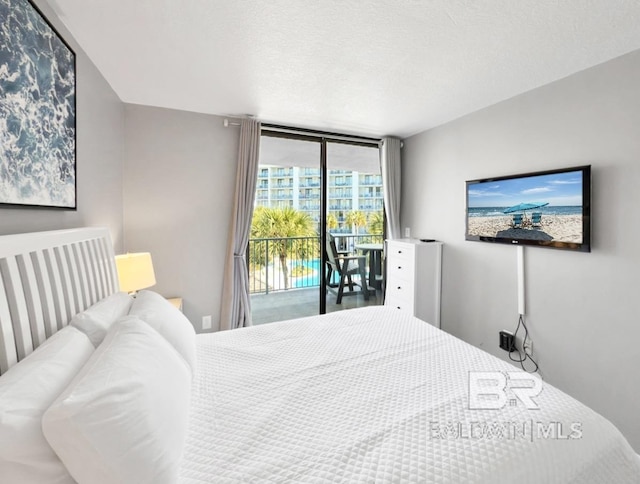 bedroom featuring a textured ceiling, access to exterior, and expansive windows