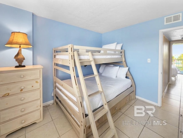 bedroom featuring light tile patterned floors, visible vents, and baseboards