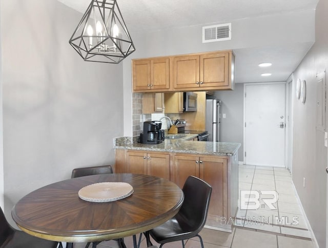 dining space featuring light tile patterned floors, visible vents, and baseboards