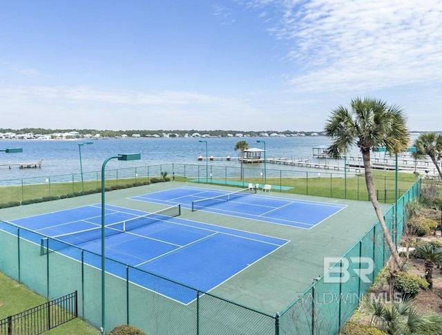 view of sport court featuring fence and a water view