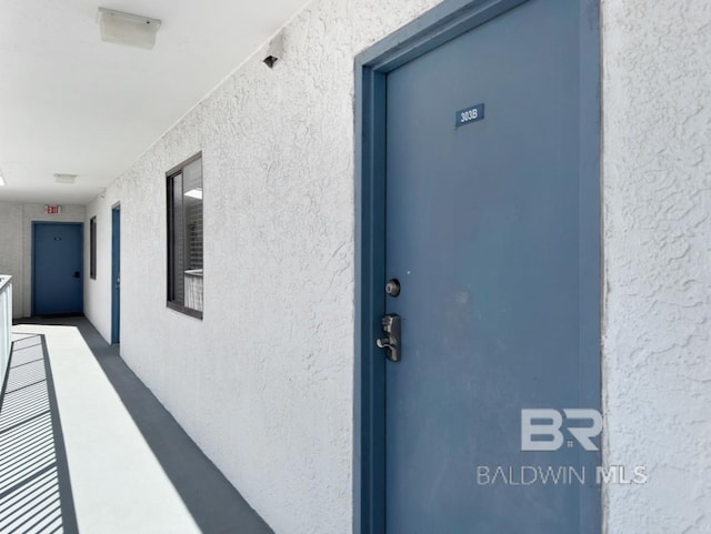 doorway to property featuring stucco siding