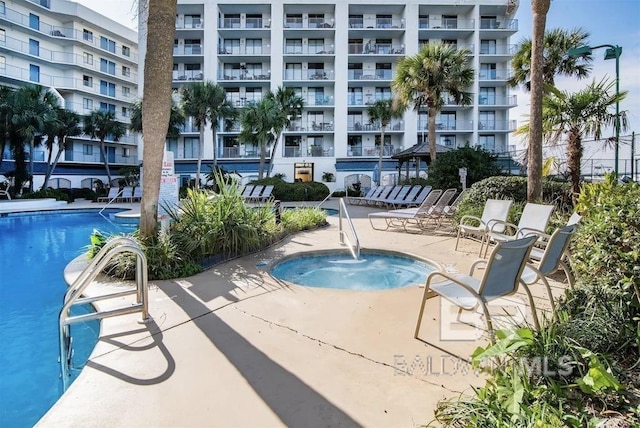 view of swimming pool featuring a patio and a community hot tub