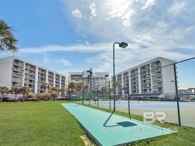 surrounding community with a tennis court, a lawn, and fence