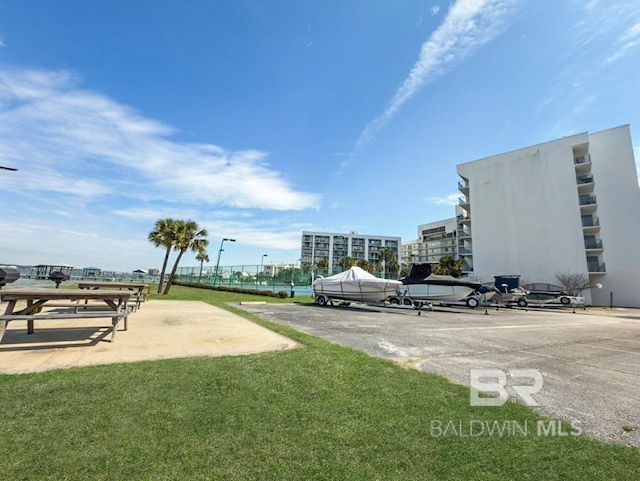 view of home's community with a yard and uncovered parking