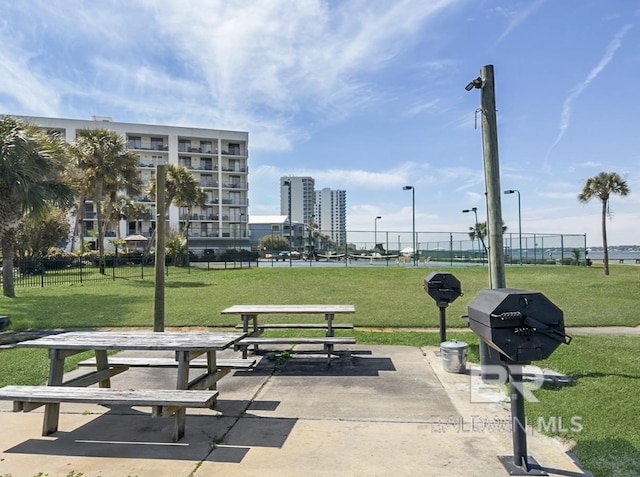 view of community featuring a lawn and fence