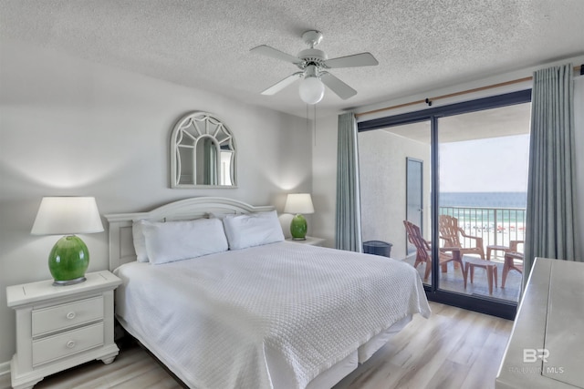 24770 Perdido Beach Blvd Unit 402, Orange Beach, AL 36561 - bedroom with light wood finished floors, access to outside, a textured ceiling, a water view, and ceiling fan