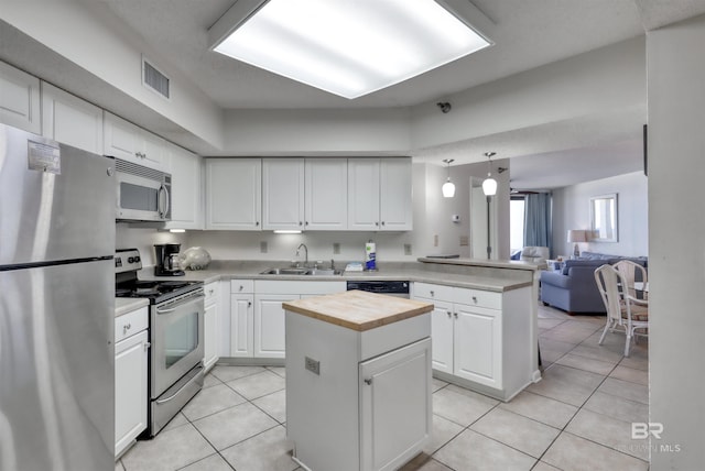 24770 Perdido Beach Blvd Unit 402, Orange Beach, AL 36561 - kitchen with appliances with stainless steel finishes, butcher block counters, a peninsula, a sink, and light tile patterned floors