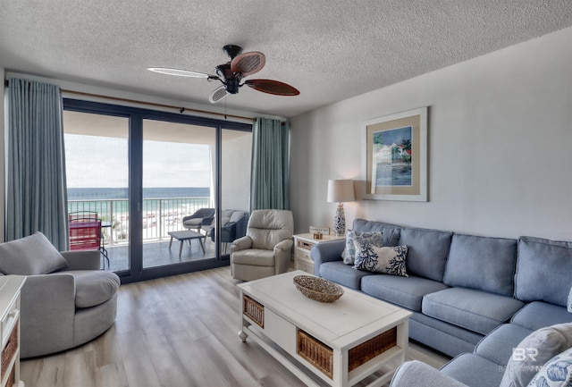 24770 Perdido Beach Blvd Unit 402, Orange Beach, AL 36561 - living room with light wood-type flooring, ceiling fan, a textured ceiling, and a water view