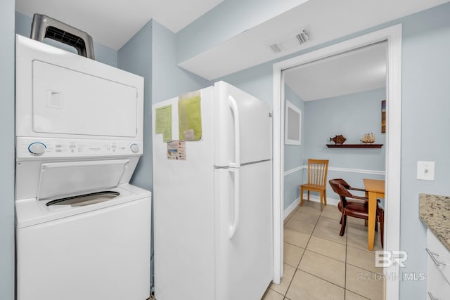 952 W Beach Blvd Unit 106, Gulf Shores, AL 36542 - laundry room with estacked washer and dryer and light tile patterned floors