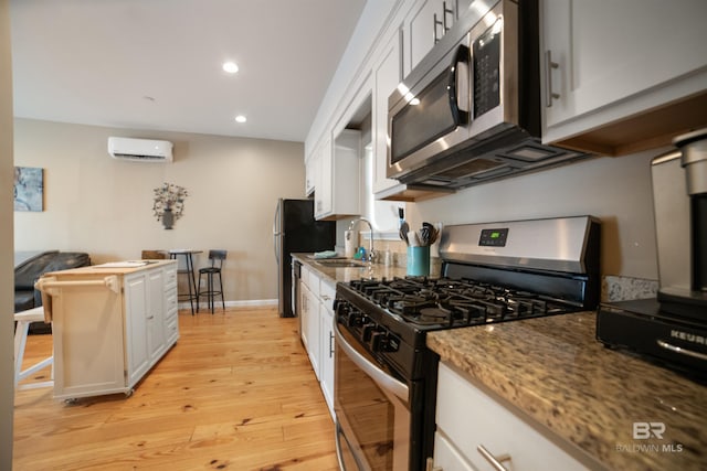 kitchen featuring white cabinetry, light wood-style flooring, a sink, and stainless steel appliances