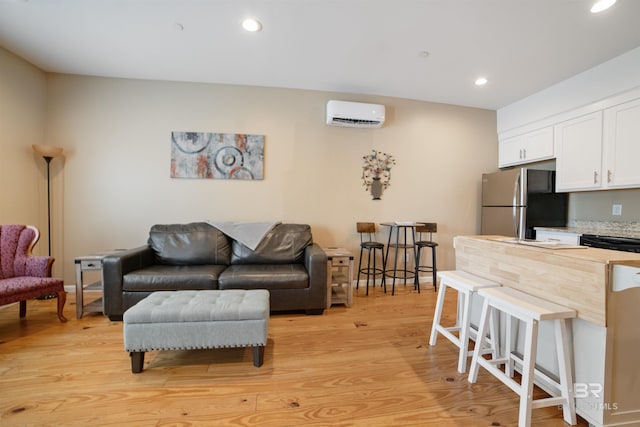 living room featuring light wood-style flooring, baseboards, a wall mounted air conditioner, and recessed lighting