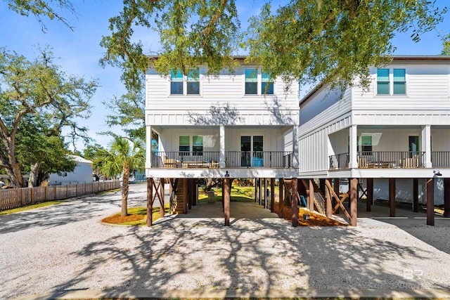 back of property featuring driveway, a porch, and a carport