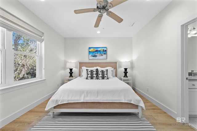 bedroom with light wood-style floors, visible vents, baseboards, and a ceiling fan