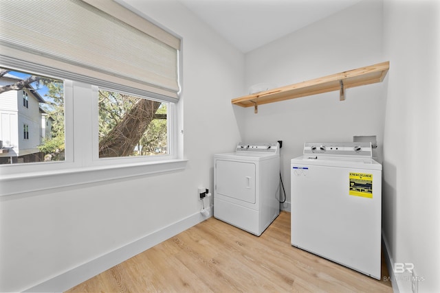 washroom featuring laundry area, baseboards, independent washer and dryer, and light wood finished floors