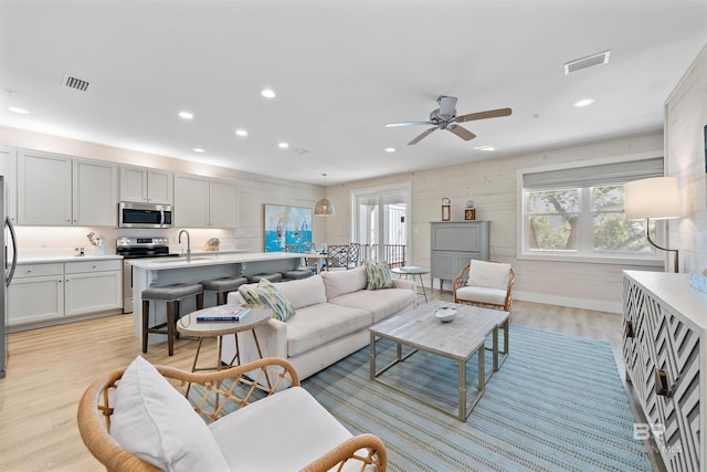 living area with light wood finished floors, visible vents, and a wealth of natural light